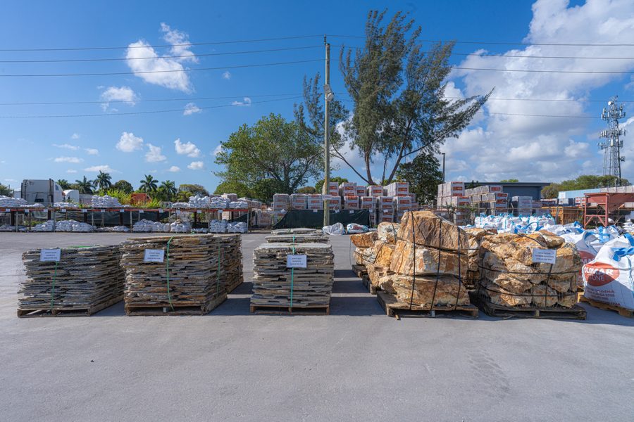 Pallets of natural stone across the Olimar Stone yard under a blue sky